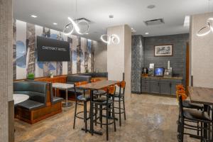 a restaurant with a bar with stools and a tv at Distrikt Hotel New York City, Tapestry Collection by Hilton in New York