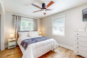 a bedroom with a bed and a ceiling fan at Mardi Gras Parade, Walk to Beach! Bay St Louis Gem in Bay Saint Louis