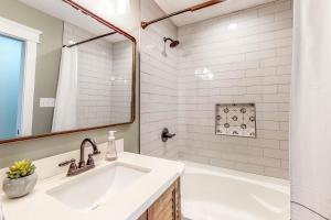 a white bathroom with a tub and a sink at Mardi Gras Parade, Walk to Beach! Bay St Louis Gem in Bay Saint Louis +16 photos