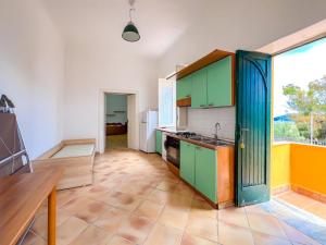 a kitchen with green cabinets and a large window at Antico Casale Ventotene in Ventotene