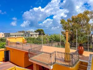 a balcony of a building with a fence and trees at Antico Casale Ventotene in Ventotene