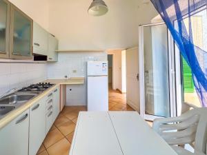 a kitchen with a white refrigerator and a sink at Antico Casale Ventotene in Ventotene