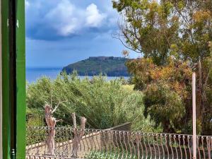 a fence with a view of the ocean and a mountain at Antico Casale Ventotene in Ventotene +1 photo