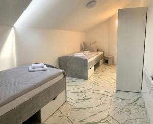 a room with two beds and a tile floor at Pent - Aparthotel Crailsheim in Crailsheim