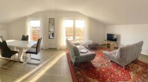 a living room with a table and chairs and a dining room at Pent - Aparthotel Crailsheim in Crailsheim