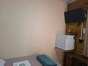 a small room with a refrigerator and a tv at Hotel Pampa in Nova Santa Medianeira