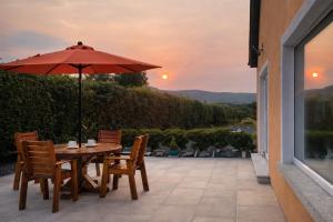 a table and chairs with an umbrella on a patio at Mon Petit Cottage - B&B and Guest House in Bunclody in Bunclody
