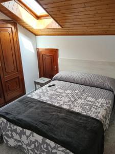 a bedroom with a bed and a wooden ceiling at Rías Baixas in Villanueva de Arosa