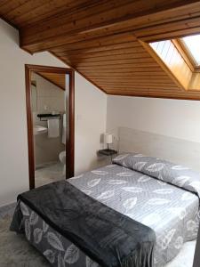 a bedroom with a bed and a bathroom with a window at Rías Baixas in Villanueva de Arosa