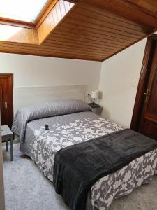 a bedroom with a large bed with a wooden ceiling at Rías Baixas in Villanueva de Arosa +15 photos