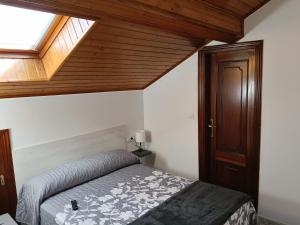 a bedroom with a bed and a wooden ceiling at Rías Baixas in Villanueva de Arosa