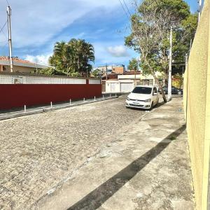 a white car parked on the side of a street at Anexo - Pousada Canaã in Recife