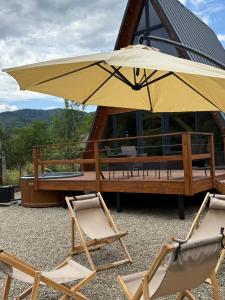 two chairs and an umbrella in front of a building at Skala House in Skole