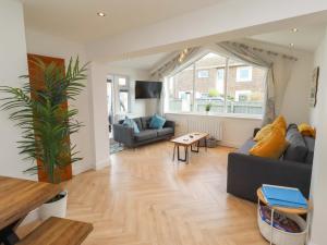 a living room with a couch and a table at Sunrise Cottage in Chathill