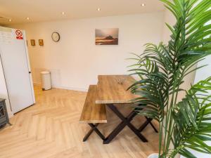 a wooden table in a room with a plant at Sunrise Cottage in Chathill