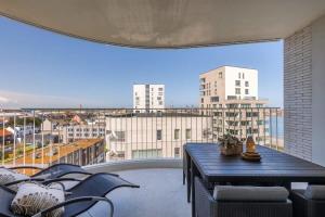 a balcony with a table and a view of a city at Casiola - Bright apartment with seaview in Bredene
