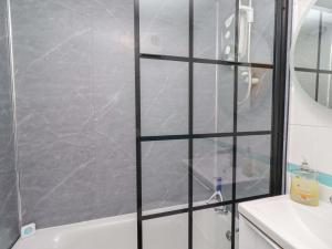 a shower with a glass door in a bathroom at Sunrise Cottage in Chathill +19 photos