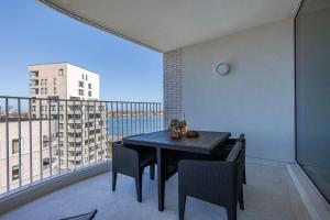 a balcony with a table and chairs and a large window at Casiola - Bright apartment with seaview in Bredene