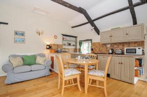 a kitchen and living room with a table and a couch at Tumrose Cottage in Blisland