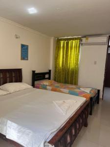 a bedroom with two beds and a green curtain at Hotel Danes Barranquilla in Barranquilla +45 photos