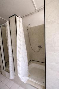 a shower with a shower curtain in a bathroom at Wellness & Nature Hostel in Pirkenhammer
