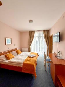 a hotel room with a large bed and a desk at Hotel Imperium in Moravske-Toplice