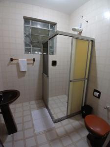 a bathroom with a shower with a toilet and a sink at Pousada Aconchegante in Jequié