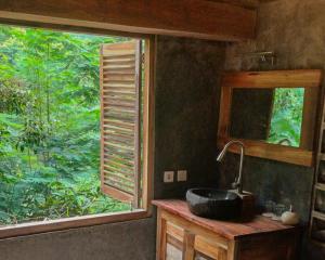a bathroom with a sink in front of a window at Munduk Umah Cabin in Munduk