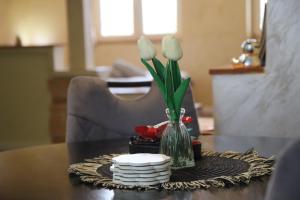 a table with a vase with white flowers in it at Apartment Slađana i Luna in Subotica +65 photos