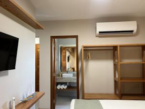a room with a bedroom with a bed and a bathroom at Sol de Marau - Taipu de Fora - próximo das piscinas naturais in Marau