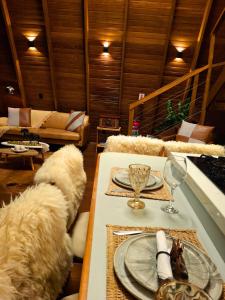a living room with a table with plates and glasses at Cabana Quatro Estações - Luxo Romântica e com vista incrível in Paty do Alferes