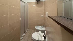 a small bathroom with a toilet and a sink at Le casette di Frà Studios in Santa Severa +55 photos