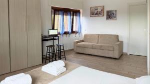 a living room with a couch and a chair at Le casette di Frà Studios in Santa Severa