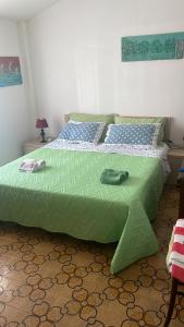 a bed with a green comforter in a bedroom at La Casa di Teresa in Scalea