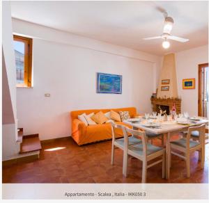 a living room with a table and an orange couch at La Casa di Teresa in Scalea