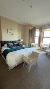a bedroom with a large bed and a chair at Dacara Bed & Breakfast in Newcastle