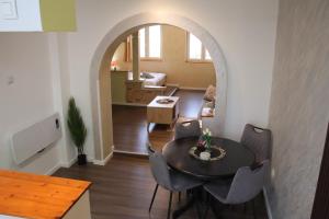 a living room with a table and chairs and an archway at Apartment Slađana i Luna in Subotica