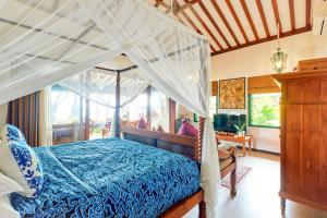 a bedroom with a bed with a canopy at Villa Kampung Kecil Beach Front in Kubu +82 photos