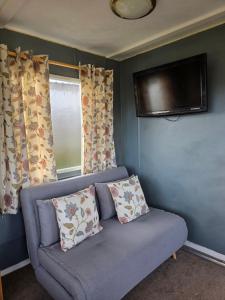 a living room with a couch and a tv at Dora's 5 Berth Static with stunning views in Saint Martin