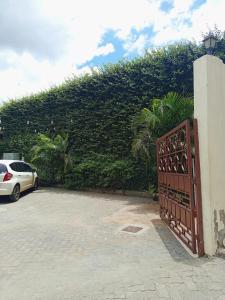 a gate in a parking lot next to a large hedge at Kitengela prime suites in Kitengela 