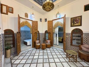 a room with arches and tables and chairs in a building at Riad AYA in Rabat