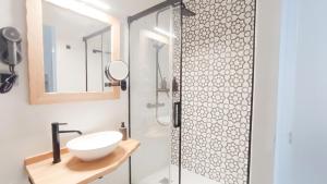 a bathroom with a shower with a sink and a mirror at El Apartamento de Hervás in Hervás
