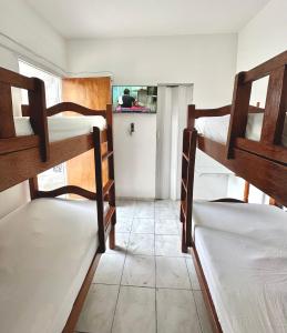a room with three bunk beds and a kitchen at Anexo Térreo - Pousada Cannã in Recife