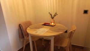 a table with chairs and a vase with a candle on it at El Apartamento de Hervás in Hervás
