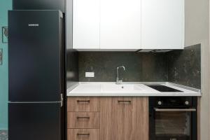 a kitchen with a black refrigerator and a sink at MARTINI APARTMENTs in Nikiti