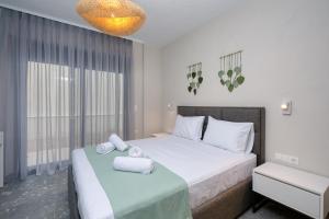 a bedroom with a bed with towels on it at MARTINI APARTMENTs in Nikiti