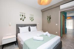 a bedroom with a bed with a green blanket at MARTINI APARTMENTs in Nikiti