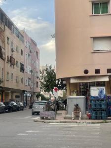 a person sitting on the side of a street at Batman in Taza