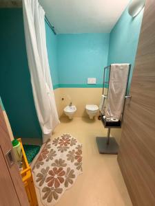 a blue bathroom with a toilet and a sink at La Casa di Lili in Nardò