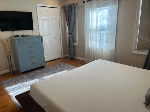 a bedroom with a bed and a dresser and a television at Downtown house w On-site Parking Walk to Capital, Museums B in Washington, D.C.